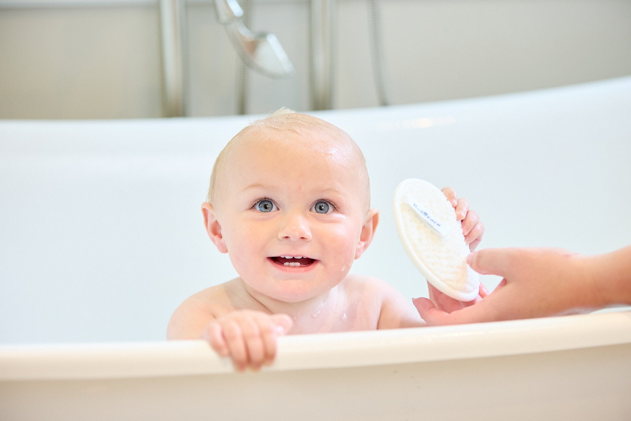 baby in tub holding pad